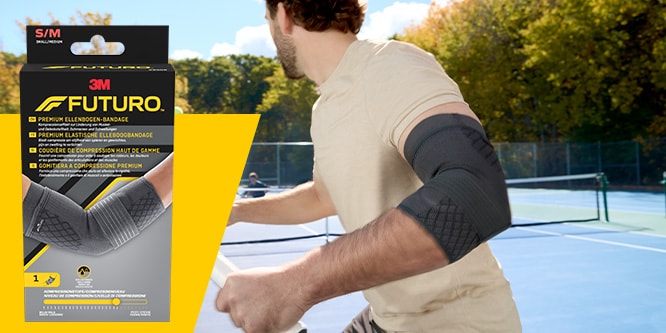 Tennista che indossa un manicotto a compressione premium per gomito FUTURO, con la confezione del prodotto visibile
